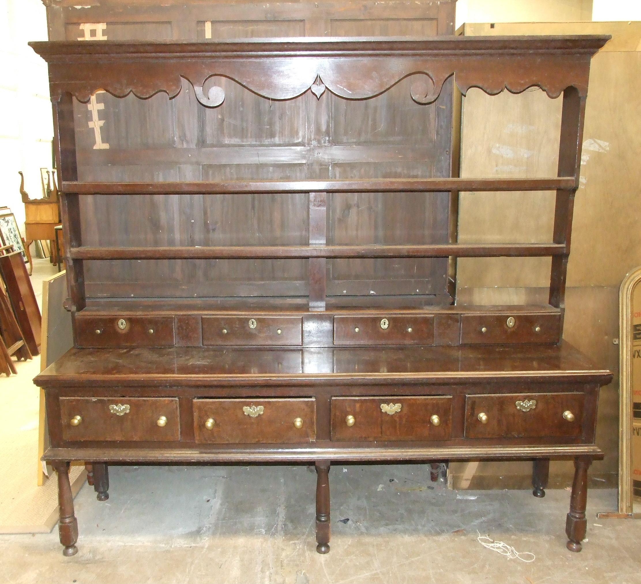 An 18th century oak dresser, the plate rack with cornice, shaped apron, three shelves and three