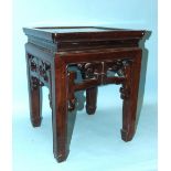 A Chinese hardwood square-topped urn stand with pierced frieze decoration, on square shaped legs,