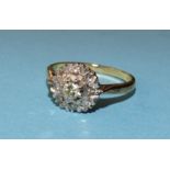 A diamond cluster ring claw-set a brilliant-cut diamond within a surround of eight 8/8-cut diamonds,