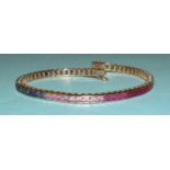 A rainbow sapphire tennis bracelet set a total of sixty-five scissor-cut fancy colour sapphires in