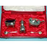 A cased three-piece silver cruet set with blue glass liners, Birmingham 1973, ___4.2oz (132.5g).