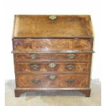 An early-18th century walnut feather-banded bureau, the fall enclosing a fitted interior above two