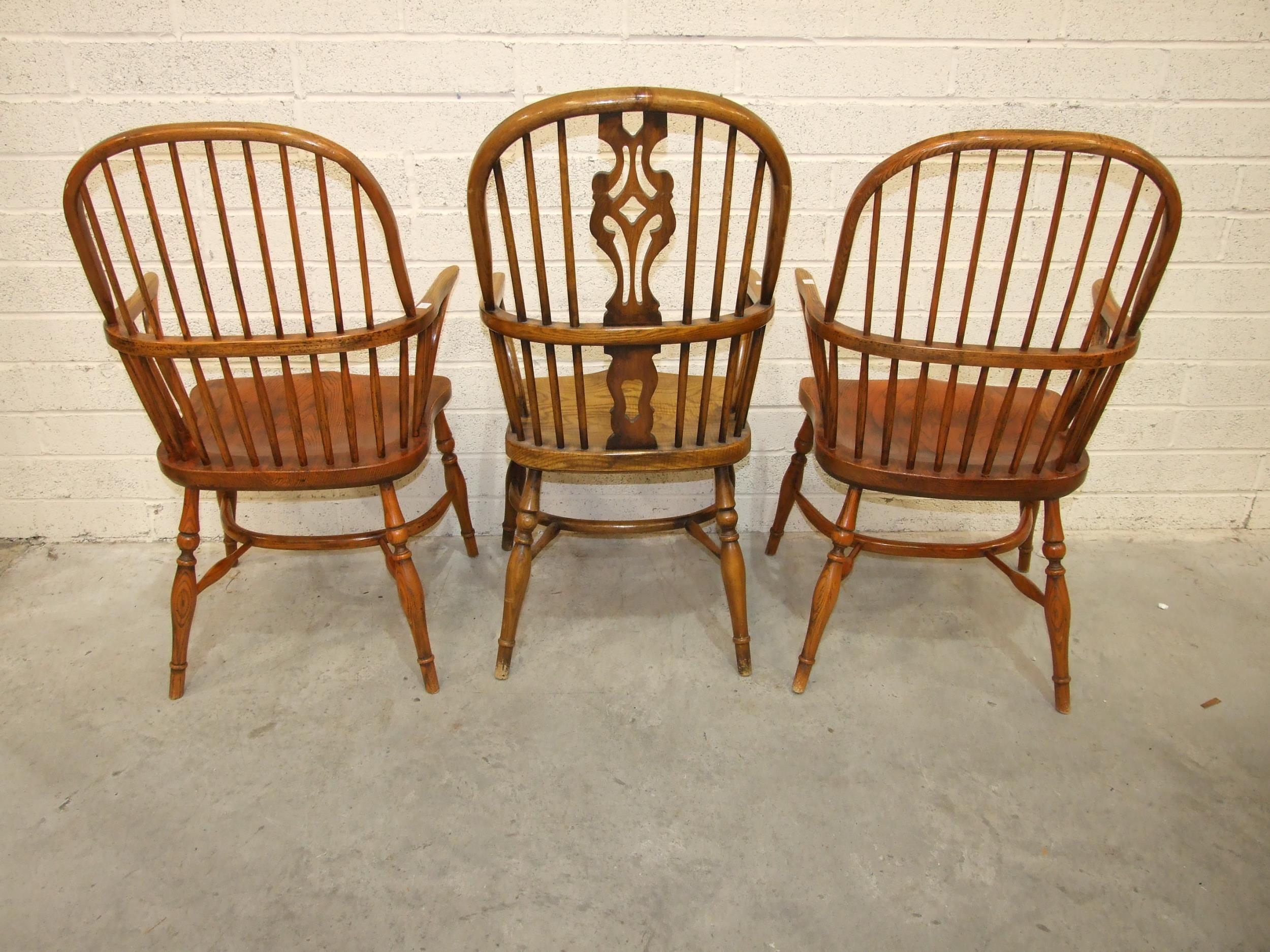 A pair of elm and beech comb-back Windsor chairs with crinoline stretchers and turned legs, (reddish - Image 2 of 4