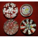 A collection of four glass paperweights, including pink twisted ribbon and lace, 7cm diameter,