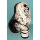 A ceramic fireside figure of the Dulux dog, with front paw resting on a tin of Dulux paint, 33cm