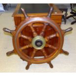 A wooden ship's wheel with brass band, 86cm diameter overall.