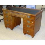 A mid-20th century knee-hole desk, the rectangular top with inset writing surface, above a long
