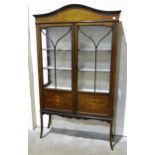 An Edwardian inlaid mahogany display cabinet fitted with a pair of glazed doors, on square