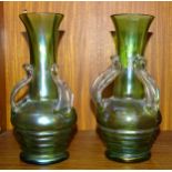 A pair of Loetz-style green glass vases each with three applied leaf handles, 21cm high.