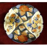A Chinese Imari ceramic wall plaque with typical decoration, 32.5cm diameter.