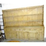 A Victorian pine kitchen dresser, the reduced plate rack with three shelves, the base with four