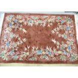 A modern Chinese rug having a salmon pink ground decorated with bamboo leaves and flowers, 275 x
