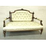 A late-Victorian walnut drawing room settee, the carved and upholstered back to scroll open arms and
