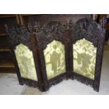 An oriental carved wood three-fold screen surmounted by warriors, each panel 93cm high, 46cm wide,