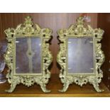 A pair of cast brass photograph frames decorated with figures and leaves, 28 x 18cm, together with