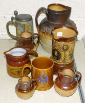 A large stoneware hunting jug, 26cm high, three smaller Doulton jugs, (one with silver mount), a