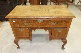 An antique walnut feather-banded lowboy, the rectangular quarter-veneered top with moulded edge,