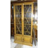 A 20th century oak two-door bookcase having a pair of astragal-glazed doors above two small panelled