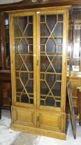 A 20th century oak two-door bookcase having a pair of astragal-glazed doors above two small panelled