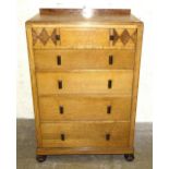 A 1930's inlaid oak chest of five graduated drawers with Bakelite handles, on octagonal bun feet, 76