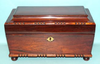 A rosewood sarcophagus-shaped tea caddy with two internal lidded compartments and glass mixing