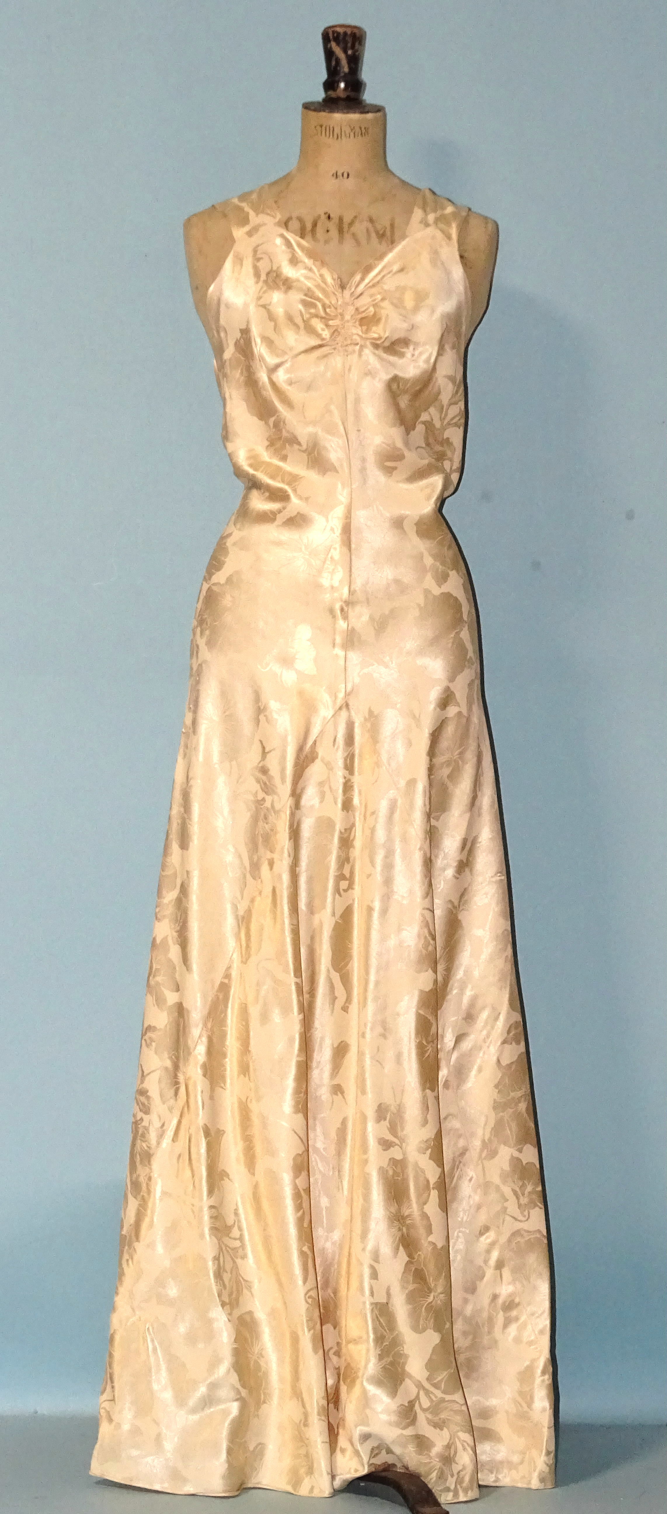 A 1930's professionally-made cream figured-satin full-length evening dress with ruched bust, bias-