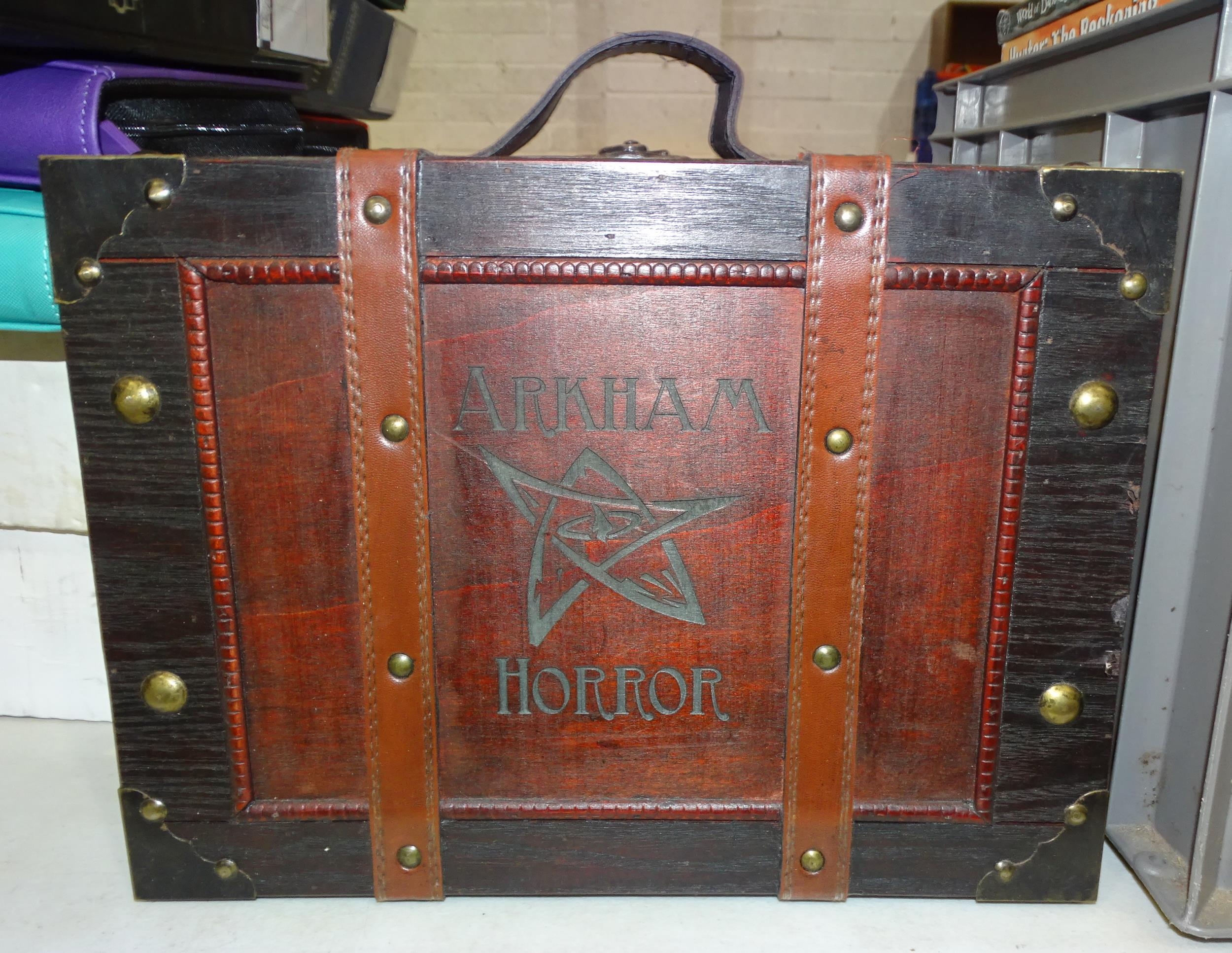 A large collection of 'Arkham Horror' game cards contained in an 'Arkham Horror' suitcase and '