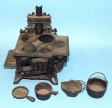 A doll's house "Queen" iron range with four pots and pans, 16 x 16cm.