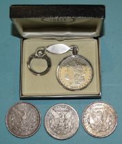 Three USA silver one-dollar coins, 1879, 1883 and 1921, together with a Swank 1883 Morgan dollar
