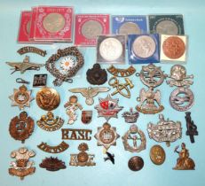 A German WWII metal eagle badge and a quantity of military and other badges.