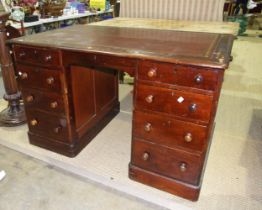 A stained pine kneehole desk, the leather-inset top above a central drawer, eight pedestal drawers