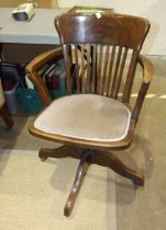 A mid-20th century oak swivel office armchair.