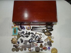 A quantity of silver and other cufflinks, various badges, coins, silver spoons, etc, in a wooden