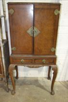 A walnut-veneered cocktail cabinet, 60cm wide, 132cm high.