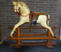 A painted fibre glass rocking horse on pine trestle base, possibly by Haddon Rockers, with glass