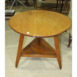 A stained pine circular 'cricket' table, on three splayed legs joined by a triangular undertier,