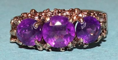 A 9ct gold ring claw-set three graduated amethysts, size Q, 4.1g.