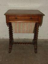 A Victorian mahogany work table, having a frieze drawer above a sliding work basket, on spiral