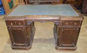 A late-19th/early-20th century oak partner's desk, the top of broken outline having two small