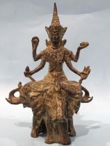 An Asian bronze and metal finial depicting Shiva? seated on three elephants, 22.5cm high.