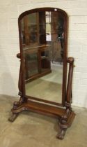 A Victorian mahogany cheval mirror, the arch plate within scroll supports, (sconces lacking),