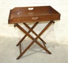 A 19th century walnut butler's tray with folding stand and a low window seat/bench on turned legs,