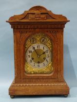 An Edwardian oak-cased mantel or bracket clock, the movement striking on four chimes and a gong, the