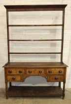 An antique oak Welsh dresser, the plate rack with some original cup hooks, the base fitted with an