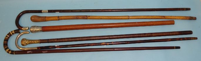 A leather washer walking cane with gilt metal top, two silver-mounted walking sticks and three