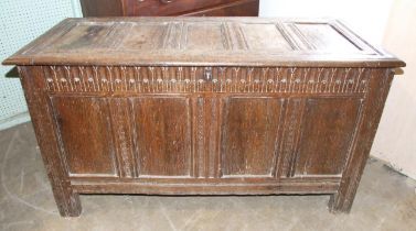 An antique oak coffer with panelled top and sides, and carved frieze, 130cm wide, 56cm deep, 71cm