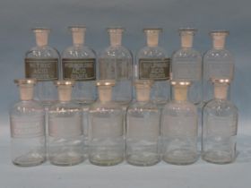 A collection of twelve glass apothecary jars with stoppers and etched labels, 17cm high, (12).