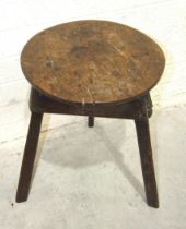 An early rustic elm cricket table on typical triangular base and splayed legs, 44cm diameter, 58cm