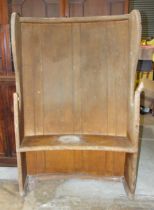 An early grained pine farmhouse settle of slightly-curved shape, 108cm wide, 166cm high, 52cm