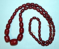 A string of sixty graduated amber-type cherry Bakelite beads, largest 25mm x 21mm, smallest 12mm x